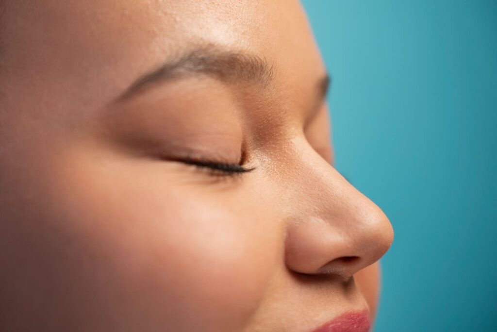 Close-up side profile of a nose after cosmetic surgery, illustrating rhinoplasty recovery and refined nasal contour.