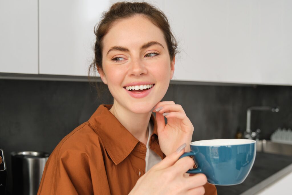 Does Coffee Stain Your Teeth More Than Tea? 14 close up portrait happy beautiful woman drinking cup tea kitchen holding mug with fresh Does Coffee Stain Your Teeth More Than Tea?